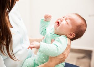 A mother holding a crying baby