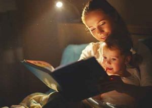 A mother reads a story to her daughter at bedtime.