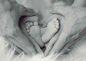 Mom and dad holding their newborn's feet!