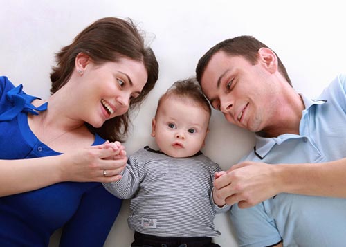 Baby lying down with his parents