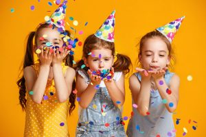 Three girls blowing confetti!