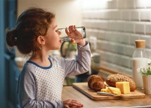 Young girl drinking a glass of water