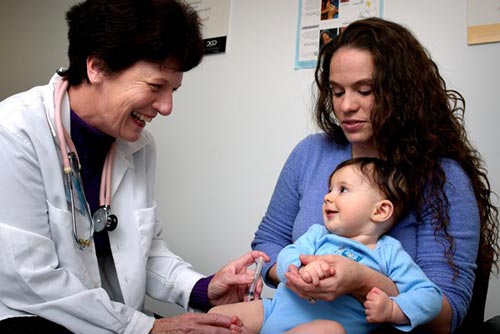 Newborn getting his vaccination shot sitting on his mother's lap!