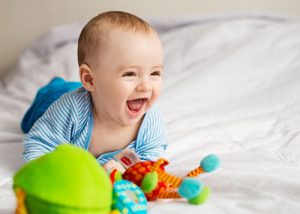 Baby on bed playing with his toys