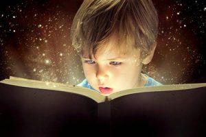 A young boy reading a book looking captivated with the galaxy and stars in the background.