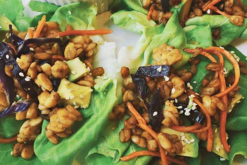 Chickpea, carrot, sesame seeds, vegetables on a bed of lettuce.