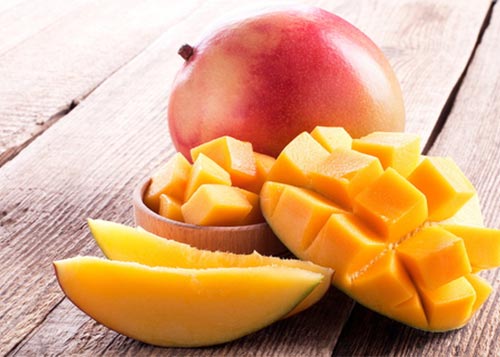 Mango slices placed on wooden planks.