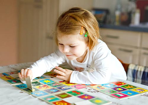 A young girl playing a memory game.