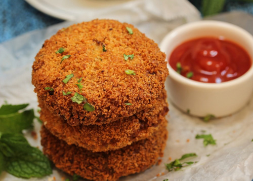 Vegetable cutlets served with ketchup.