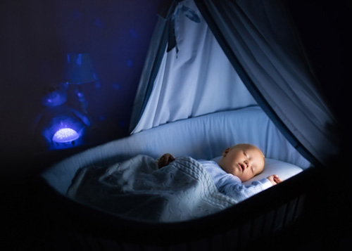 A baby asleep in a bassinet.