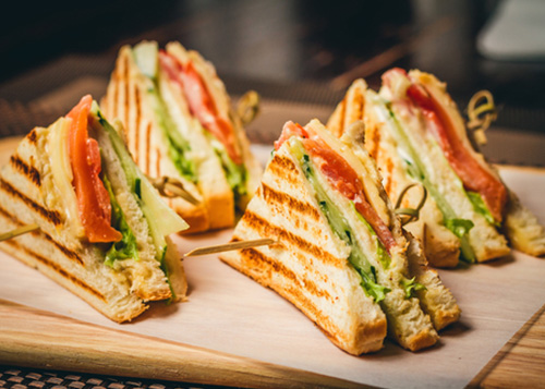 Grilled sandwiches placed on a chopping board.