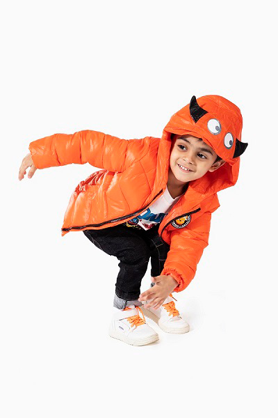 Boy wearing an orange puffer jacket.