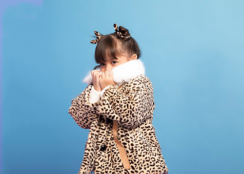 Girl wearing a faux fur coat with animal print.