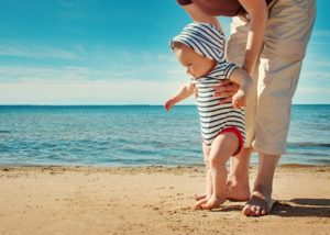 Mother teaching her infant how to walk