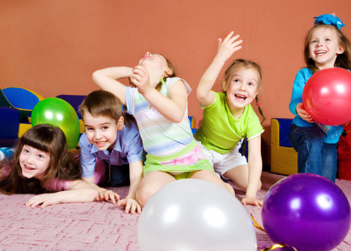 Kids playing and laughing with balloons around