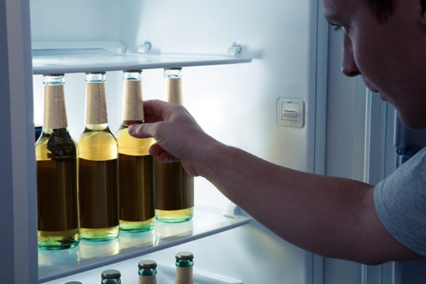 Man taking a beer bottle from a refrigerator