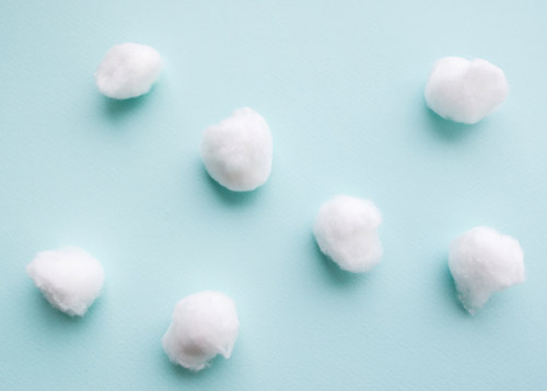 Cotton balls against a baby blue background