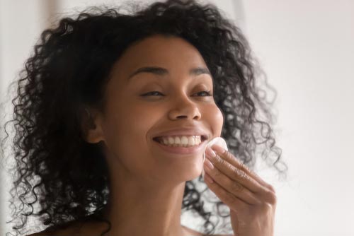 Woman using a chemical exfoliator with a cotton pad