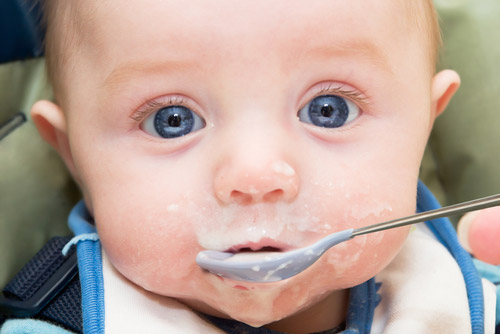 Baby being fed cereal