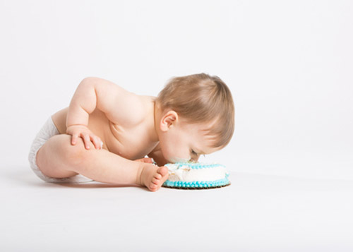 Baby with it's face in birthday cake!