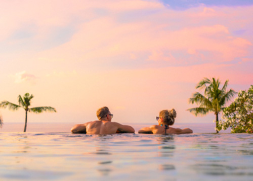 A couple lounging at the edge of a pool