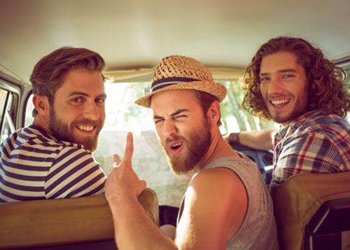 Three men sitting in a car having fun