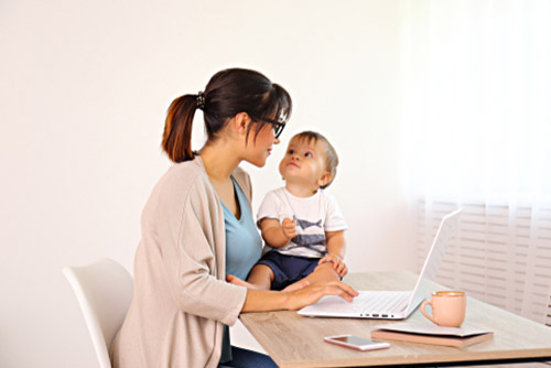 Cute boy with mom working on a laptop.