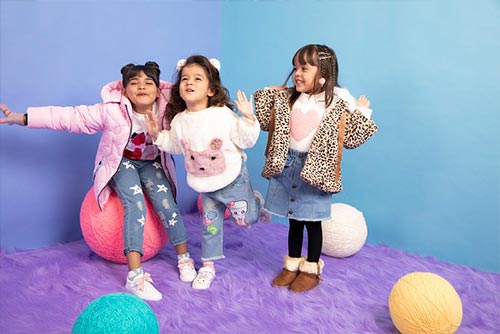 Group of girls dressed in winter wear singing.