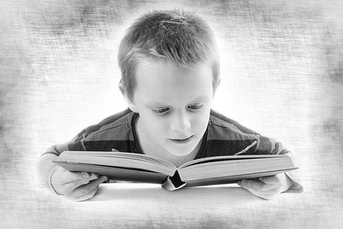 Boy reading a book intently!