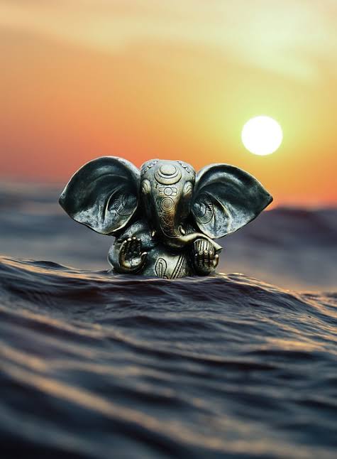 A small Ganesha sculpture floating in the water