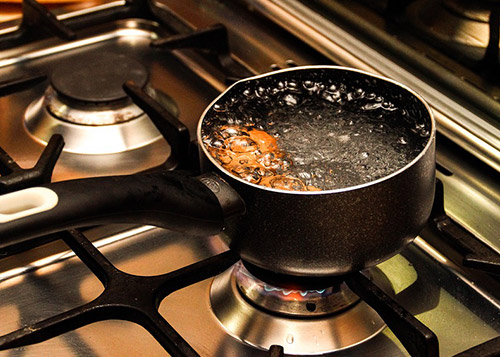 Eggs in a pot of boiling water placed on a stove