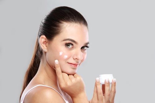 Woman applying a cream to her face