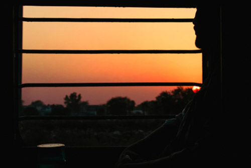 A man sitting by the window of a train.