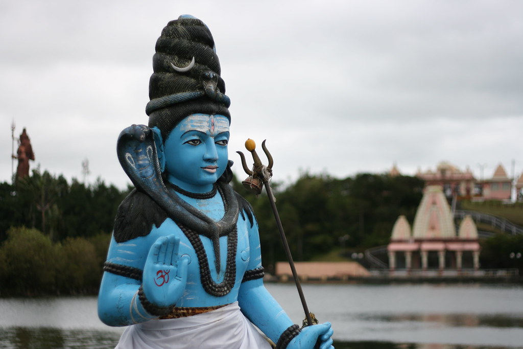 Shiva statue next to a pond