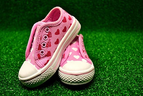 A pair of pink-coloured canvas shoes.