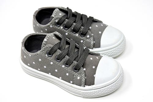 A pair of grey canvas shoes with stars.