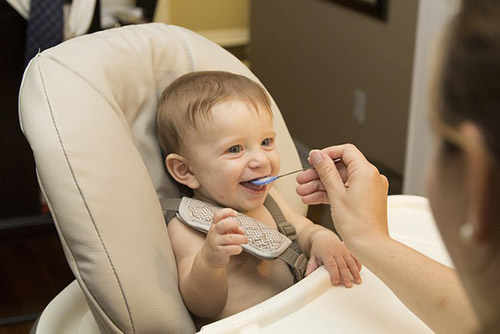 Baby in a high chair being fed