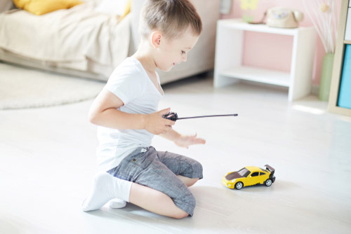 Boy playing with a remote-controlled car.