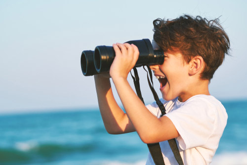 Boy looking through binoculars.