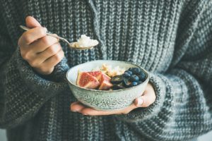 A woman eating some healthy winter fruits.