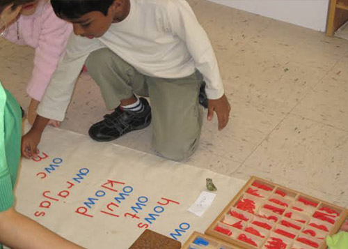 A young boy arranges blocks to learn how to form words.