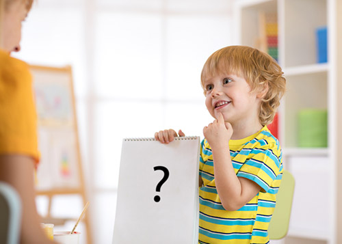 A young student looks at the teacher while thinking of the answer to a question.