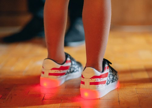 A kid wearing a pair of cool LED shoes.
