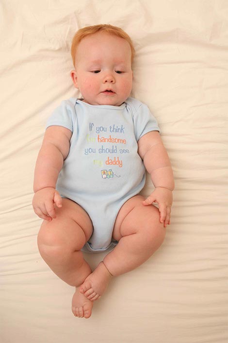 Baby in a onesie lying down on its back