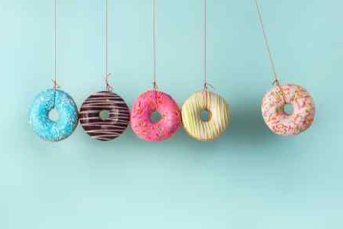 Different flavoured doughnuts hanging off of a string.