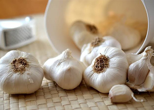 Cloves of garlic spilling out of a box
