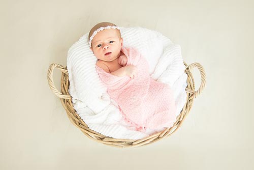 Baby lying down in a basket