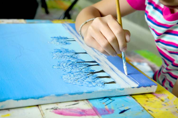Young girl painting on a canvas with a paintbrush!