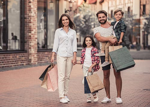 A couple along with their two kids carrying shopping bags on the street