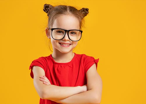 A cheerful bespectacled young girl wearing bold red top set against yellow background